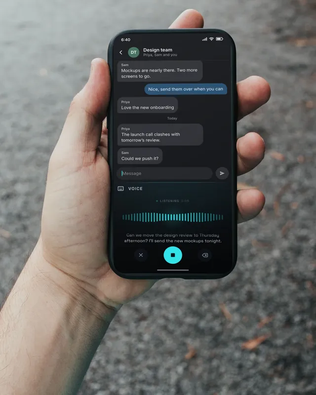 A phone held up on a walk, over a gravel path. On the screen, Keyey’s voice panel is typing a reply.